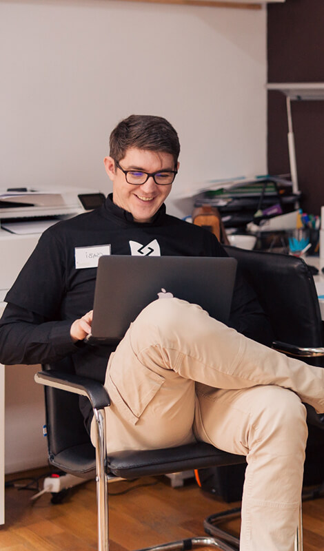 A person sitting in a chair using a laptop. 